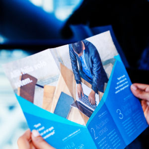 a person is holding a blue brochure