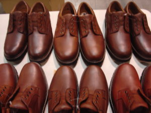a row of brown shoes are lined up on a table