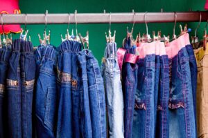a row of blue jeans hanging on a rack